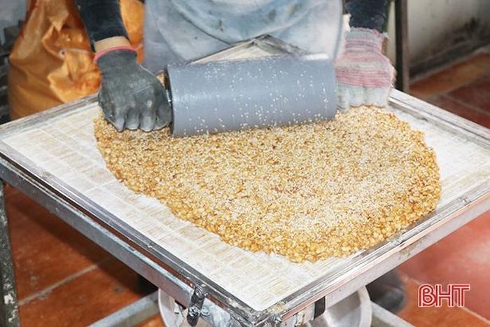 ... rồi phải thật nhanh tay cán theo chiếc khuôn để hạt mè rang bám đều các mặt