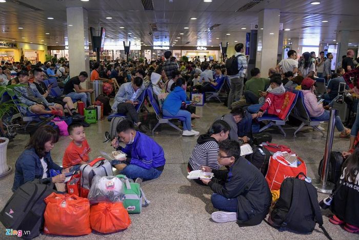  Bên trong khu vực chờ, ghế ngồi kín chỗ, nhiều người phải ngồi dưới nền. 