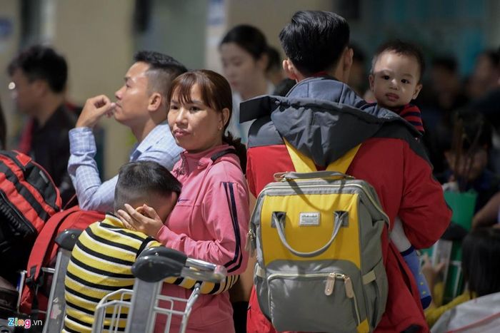  Nhiều trẻ em mệt mỏi gục đầu vào cha mẹ trong lúc chờ làm thủ tục. Cảng hàng không quốc tế Tân Sơn Nhất cho biết lượng khách trung bình nơi đây là 130.000 người mỗi ngày, tăng 10.500 khách so với dịp Tết năm trước. 