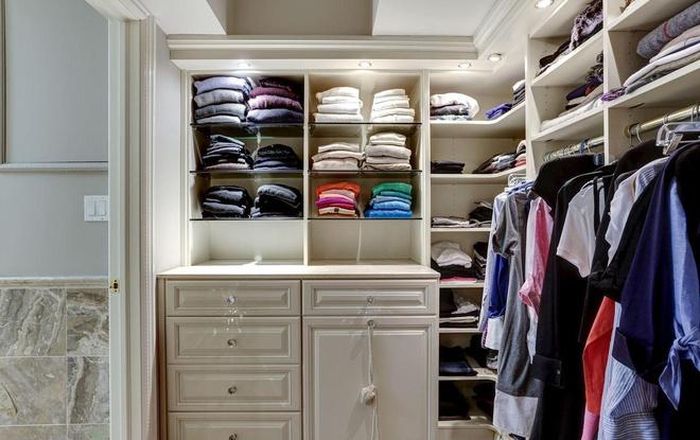  Ngôi nhà được thiết kết một phòng riêng dùng để treo quần, áo. Những bộ đồ được sắp xếp gọn gàng, ngăn nắp trong một tủ lớn bằng gỗ. 