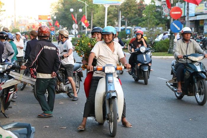 Những nụ cười, nói rộn rã của người mua, người bán hòa vào tiếng còi xe tấp nập trên những tuyến phố ngập tràn sắc màu rực rỡ của cờ hoa… đã làm nên chiếc áo mới đầy ấn tượng trong những ngày xuân tại Ninh Thuận. (Ảnh: Duy Quan).