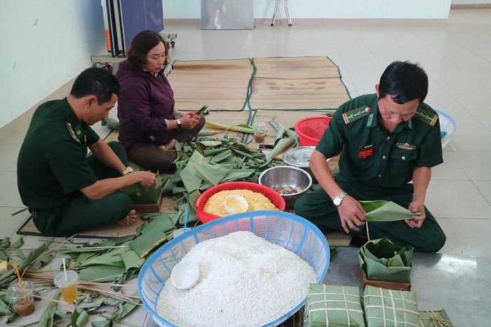 Các chiến sĩ biên phòng tham gia gói bánh.