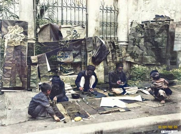  Nhiều người nhận ra những góc thân quen của Hà Nội qua hình ảnh được phục chế màu. Bộ ảnh đã giúp nhiều người hiểu thêm hoạt động trong ngày Tết của người dân Hà thành cách đây 100 năm. Trong ảnh, trẻ con đang xin chữ ông đồ. 