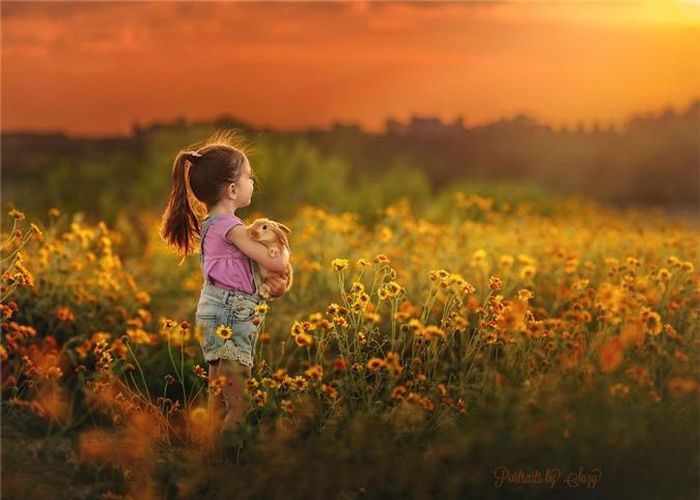  Mia ôm thỏ đững giữa cánh đồng hoa nở rực rỡ. 