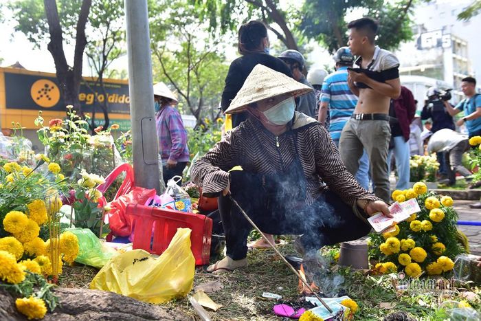 Một tiểu thương đốt vàng mã xả xui khi hoa bán không hết