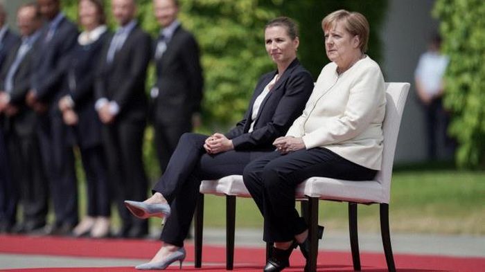 Thủ tướng Đan Mạch Mette Frederiksen và Thủ tướng Đức Angela Merkel ngồi nghe quốc ca trước cuộc họp chính thức, ngày 11/7/2019. (Ảnh: DPA)