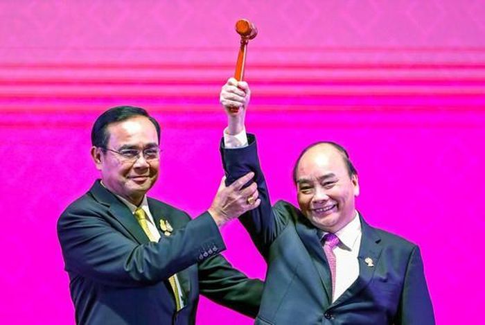Thủ tướng Nguyễn Xuân Phúc (phải) nhận chiếc búa Chủ tịch ASEAN 2020 từ Thủ tướng Thái Lan. Ảnh: REUTERS
