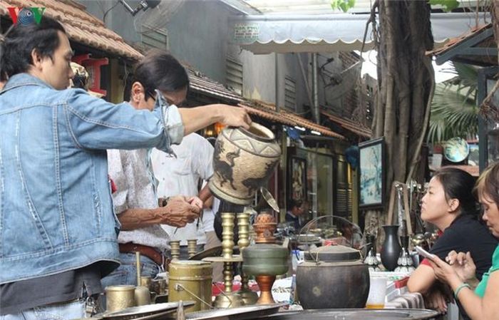  Chủ cửa hàng nhiệt tình giới thiệu về món đồ mình có. Khi ưng một món đồ, những khách hàng rất chăm chú. Giá của những món đồ ở đây dao động từ vài trăm ngàn đồng cho tới hàng nghìn USD. 