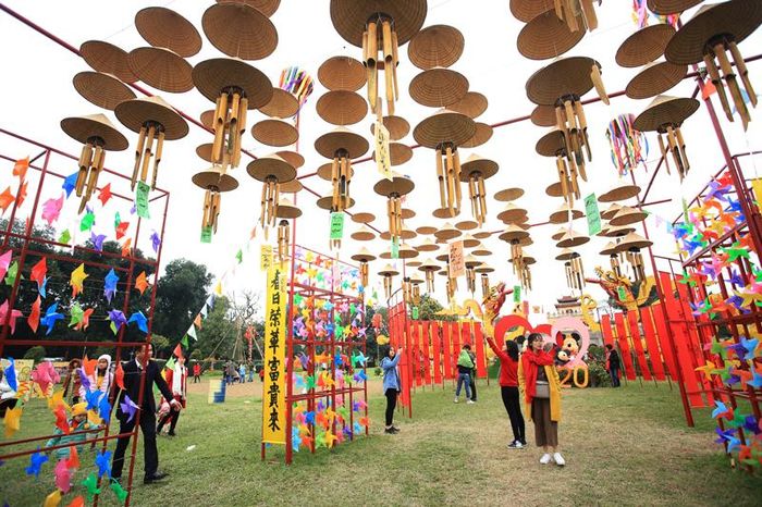 Khách du lịch hào hứng chụp ảnh cùng các cụm trang trí độc đáo với chuông gió, nón, chong chóng ...