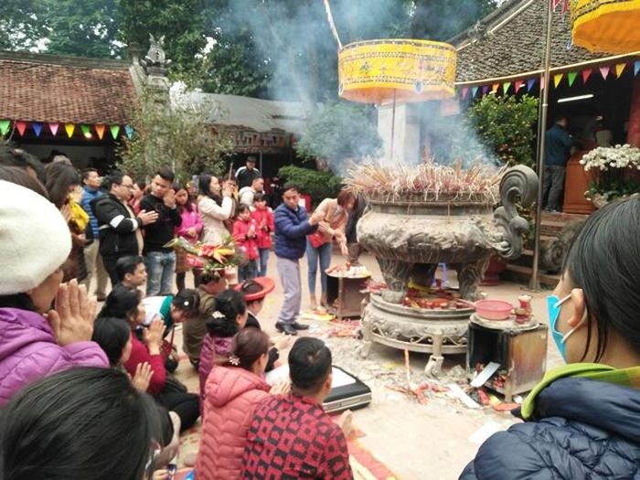 Một gia đình hành lễ ngay tại sân đền Và. Ảnh: Bình Thanh