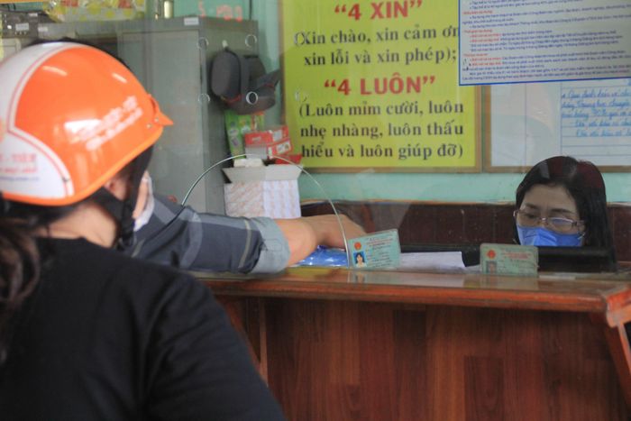 Một nhân viên nhà ga đeo khẩu trang khi làm thủ tục cho hành khách