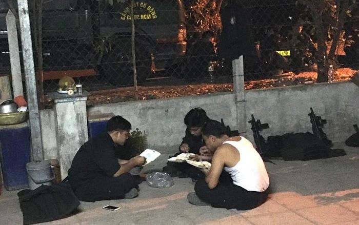 Các Cảnh sát cơ động tranh thủ ăn tối để tiếp tục làm nhiệm vụ. Ảnh: N.YÊN