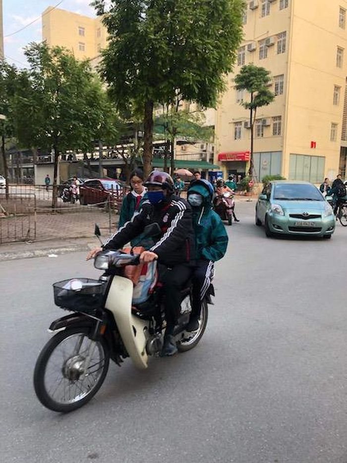 2 bố con cẩn trọng khi cùng sử dụng khẩu trang khi đến trường. Ảnh: Nhật Nguyên