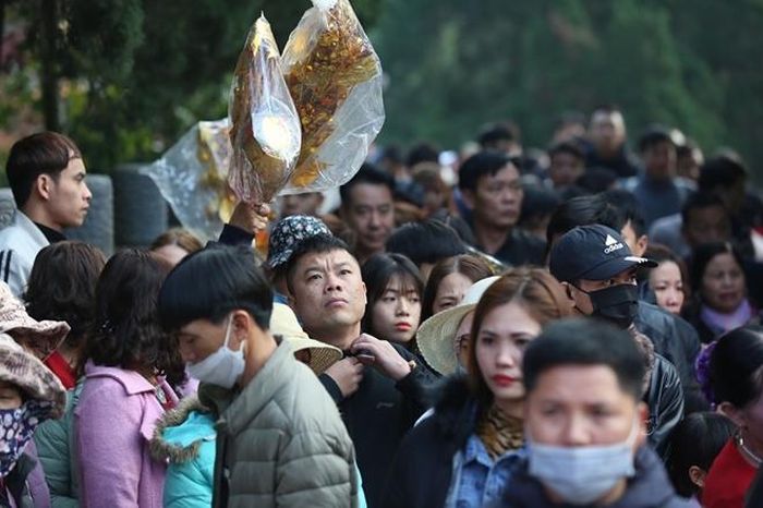 Người đông, đường chật, nhiều du khách phải giơ đồ lễ lên trời để tránh bị bẹp, méo