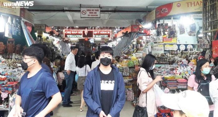 Lo ngại về dịch bệnh do virus corona tại Trung Quốc lây lan, 2 nam du khách nước ngoài đeo khẩu tra khi tham quan tại các gian hàng bán đồ lưu niệm trên đường Trần Phú, Đà Nẵng.