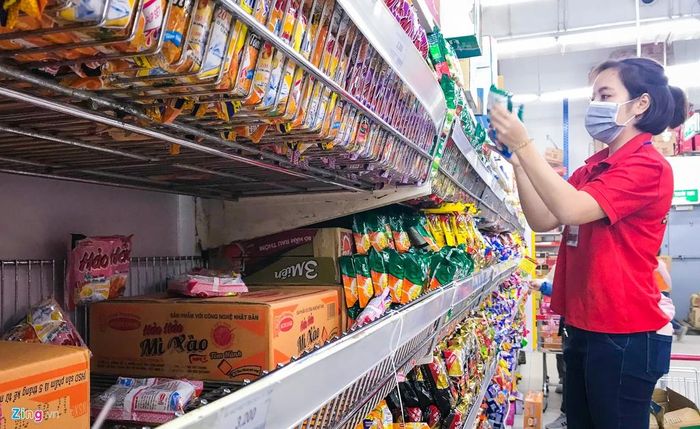  Nhân viên siêu thị liên tiếp đứng xếp mì tôm lên kệ do lượng mua rất lớn, chỉ một thời gian ngắn đã vơi hàng. 