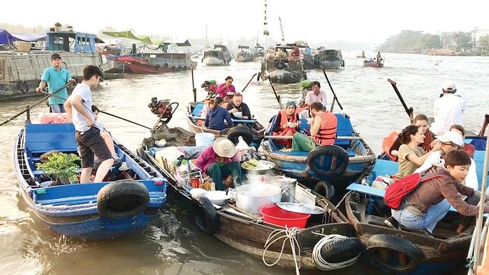 Ngày xuân khách nước ngoài thưởng thức món ăn trên chợ nổi Cái Răng. Ảnh: CAO PHONG