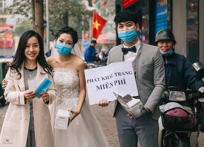  Không chỉ các cửa hiệu, cửa hàng kinh doanh, nhiều bạn trẻ đã tự bỏ tiền túi mua khẩu trang và phát miễn phí cho mọi người. Khi thực hiện bộ ảnh cưới trên đường phố Hà Nội, Ngọc Vy - Đình Đăng mua 2.000 chiếc khẩu trang phát miễn phí cho người dân qua đường. Hành động của đôi trẻ đang nhận được nhiều lời khen. Ảnh: NVCC. 