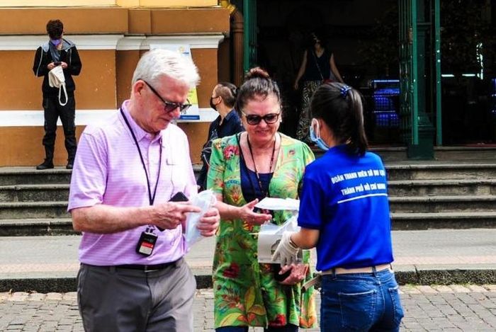 Nhân viên Sở Du lịch Thành phố Hồ Chí Minh phát khẩu trang miễn phí cho khách du lịch. Ảnh: Đinh Hằng – TTXVN