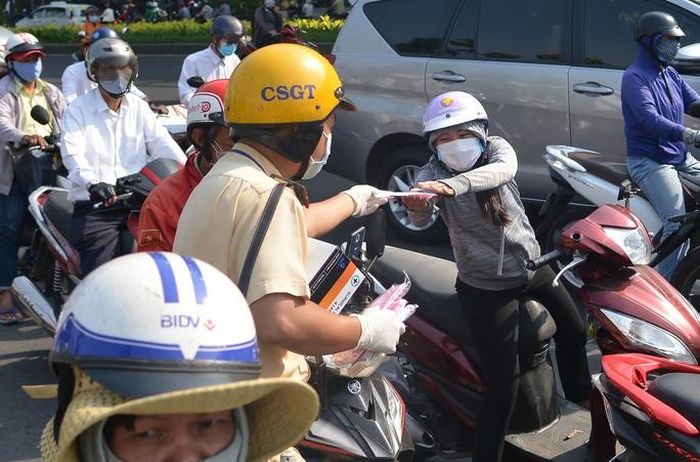 CSGT trước khi phát khẩu trang được đeo găng tay y tế nhằm đảm bảo vệ sinh.