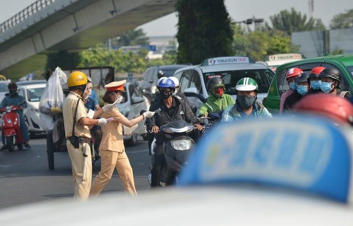Tiết trời ngột ngạt, CSGT đội nắng phát khẩu trang cho người đi đường