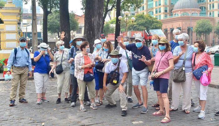Du khách đến tham quan TPHCM được phát khẩu trang miễn phí phòng ngừa dịch nCoV. Ảnh: THI HỒNG