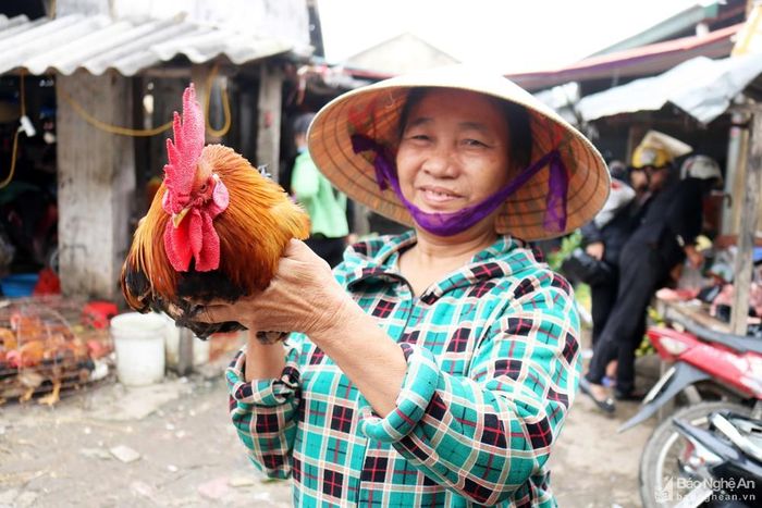 Một phụ nữ Thanh Chương đi chợ sắm Rằm hài lòng khi mua được một con gà trống cỏ. Giá gà giò loại ngon bán lẻ ở các chợ giao động từ 120 - 125 nghìn đồng/kg.