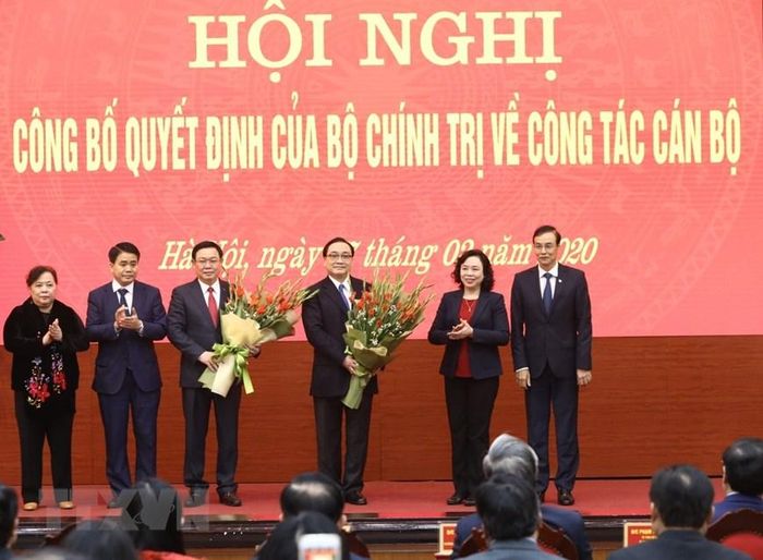 Lãnh đạo Thành ủy Hà Nội tặng hoa, chúc mừng hai ông Vương Đình Huệ và Hoàng Trung Hải được phân công nhiệm vụ mới. (Ảnh: Văn Điệp/TTXVN)
