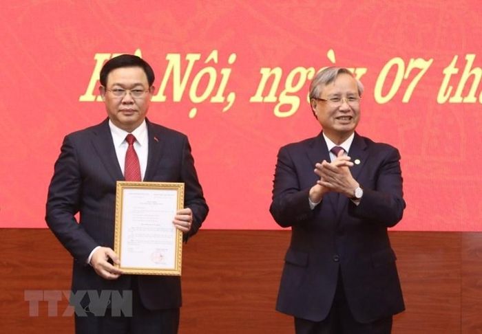 Thường trực Ban Bí thư Trần Quốc Vượng trao quyết định bổ nhiệm đồng chí Vương Đình Huệ làm Bí thư Thành ủy Hà Nội.(Ảnh: Văn Điệp/TTXVN)