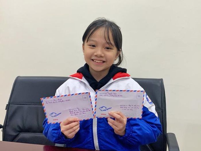 Em Nguyễn Ngọc Trinh (học sinh lớp 4 Trường tiểu học Đoàn Thị Điểm, Hà Nội) cùng bức thư gửi Thủ tướng và gửi tặng cho Thành đoàn Hà Nội số tiền lì xì trên 3 triệu đồng góp vào mua khẩu trang, nước rửa tay cho bà con. Ảnh: Mai Anh/báo Tuổi trẻ