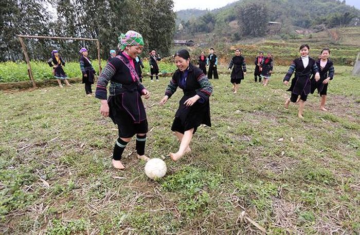 Các nữ cầu thủ chân đất đá bóng.