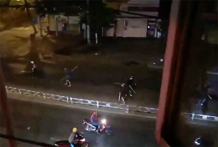 Nhiều thanh niên cầm mã tấu chạy ra đường. Ảnh cắt từ clip