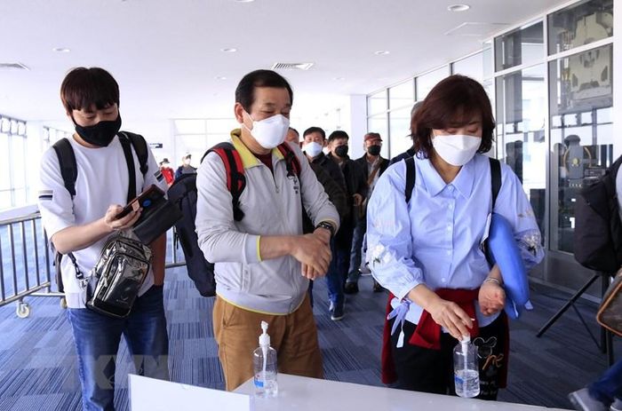 Hành khách đến Lào qua các cửa khẩu quốc tế sẽ được kiểm tra thân nhiệt, sau đó sẽ được yêu cầu sát khuẩn tay trước khi nhập cảnh Lào. (Ảnh: Phạm Kiên/Vietnam+)