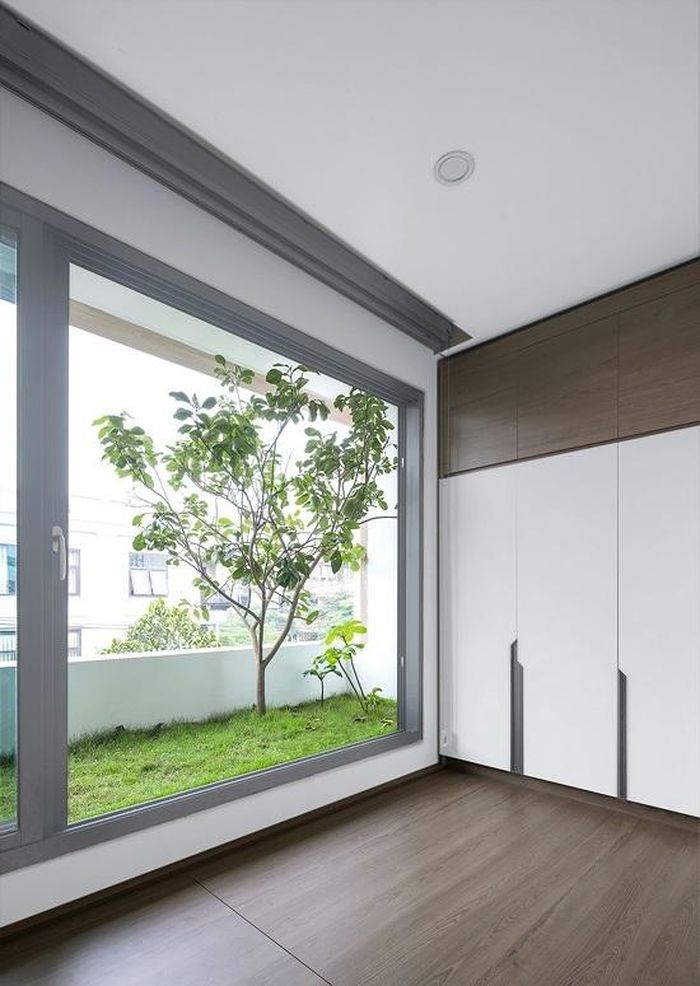 Hệ kính lớn giúp các phòng gần gũi với thiên nhiên. Để lấy thêm nắng và gió, phía sau nhà, nhóm kiến trúc sư bố trí khoảng thông tầng rộng 90 cm dài hết mảnh đất (11 m).