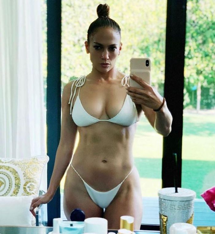  Jennifer Lopez khoe cơ thể săn chắc đáng ngưỡng mộ ở tuổi 51 trong bộ bikini trắng nhỏ xíu. Bí quyết giữ dáng của nữ ca sĩ là điên cuồng tập gym, múa cột kết hợp chế độ ăn uống khoa học chú trọng nhiều vào rau xanh. 