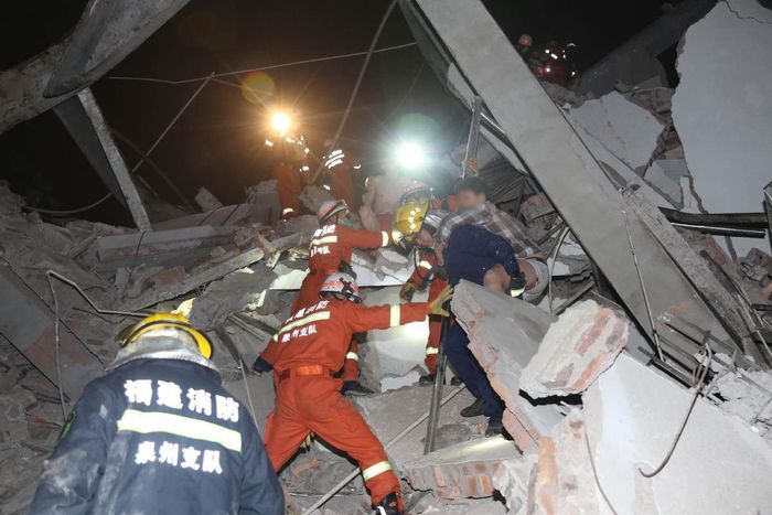 Đội cứu hộ đưa một nạn nhân ra khỏi hiện trường - Ảnh: China Daily