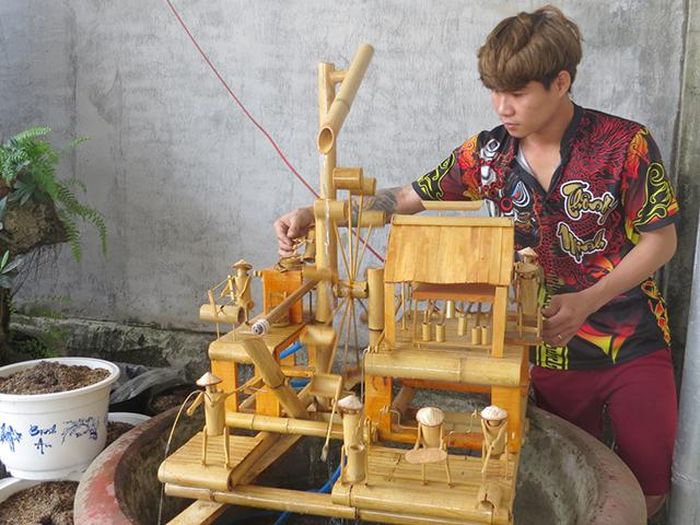 Anh Nguyễn Hữu Minh bên mô hình thủ công mỹ nghệ bằng tre trúc của mình