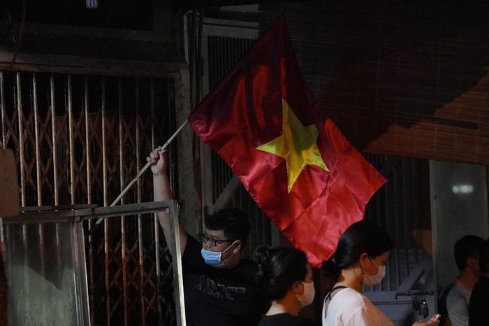 Từng hộ dân sống bên trong khu cách ly cắm cờ trước cửa nhà thể hiện niềm vui