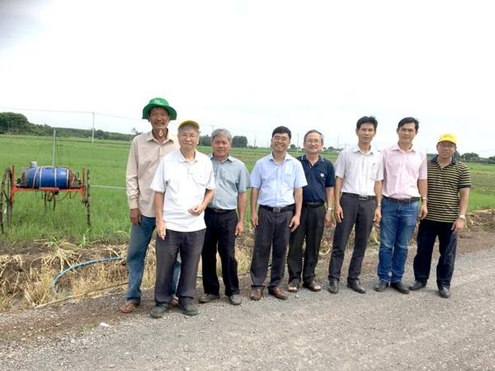 Ông Trần Quang (bìa trái) chụp hình cùng các kỹ sư, giảng viên Trường đại học Nông lâm TP.HCM tham quan mô hình máy phun thuốc trừ sâu