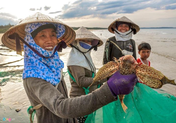  Sau một ngày lao động mệt nhọc, họ vui vẻ với mẻ thủy sản tươi rói bên bờ biển. 
