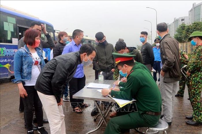 Hành khách khai báo y tế và lịch trình di chuyển cho lực lượng chức năng chốt số 2 (Quảng Ninh). Ảnh: Bùi Hiếu/TTXVN