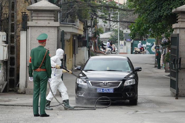Nhân viên xe khử trùng cơ động của Viện Y học Dự phòng Quân đội khử khuẩn mọi phương tiện vào Cục Quân y, chiều 22/3 - Ảnh: Nguyễn Minh