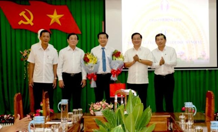 Phó Chủ tịch UBND tỉnh Nguyễn Thanh Hùng trao quyết định và tặng hoa chúc mừng đồng chí Trần Minh Lý (Ảnh: N.Ánh)