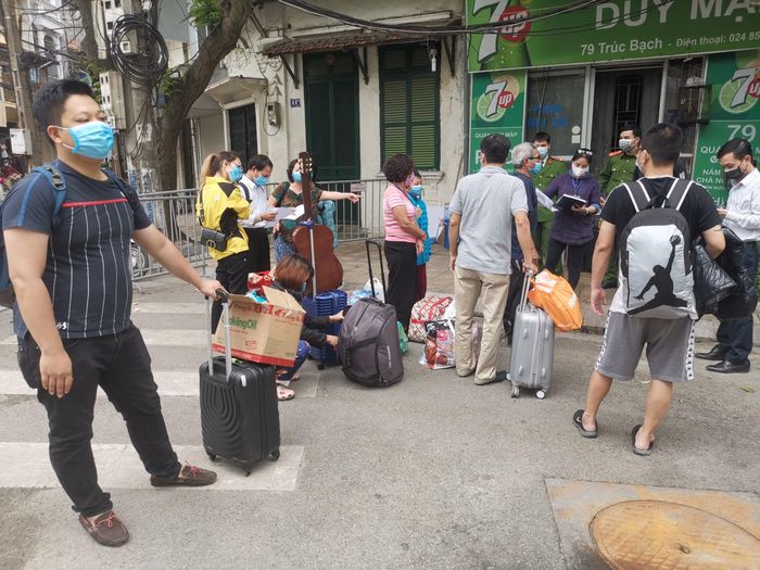 Anh Long (bìa trái) chuẩn bị rời phố đến khu cách ly Ảnh: Phạm Long