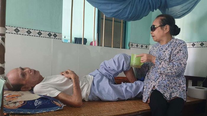 Cụ bà Nguyễn Thị Huê bị mù phải gắng mò mẫm đút từng thìa cháo cho chồng là cụ ông Nguyễn Văn Nữ