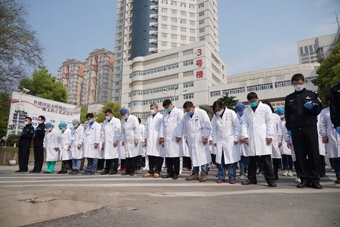 Các y bác sỹ mặc niệm trong lễ quốc tang tưởng nhớ các liệt sỹ và bệnh nhân tử vong vì đại dịch COVID-19 ở Vũ Hán, tỉnh Hồ Bắc, Trung Quốc ngày 4/4/2020. (Nguồn: THX/TTXVN)