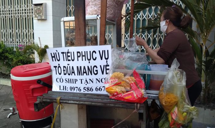 Thời gian này, để có thể kinh doanh tiếp thì tất cả hàng quán ăn uống đều chỉ được bán cho khách mang về.Trong ảnh: Một quán hủ tiếu ở Q.9 đến lúc phải áp dụng hình thức "ship hàng" cho khách bên cạnh việc bán mang đi. 
