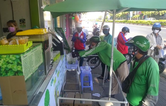 Một cửa hàng nước giải khát trên đường Cộng Hòa (Q. Tân Bình) thiết kế khung giãn cách giữa khách và nhân viên. Hàng được nhân viên chuyền đến một chiếc rổ ở khu vực an toàn và khách nhận hàng tại đó, tránh giao dịch trực tiếp giữa khách và nhân viên.