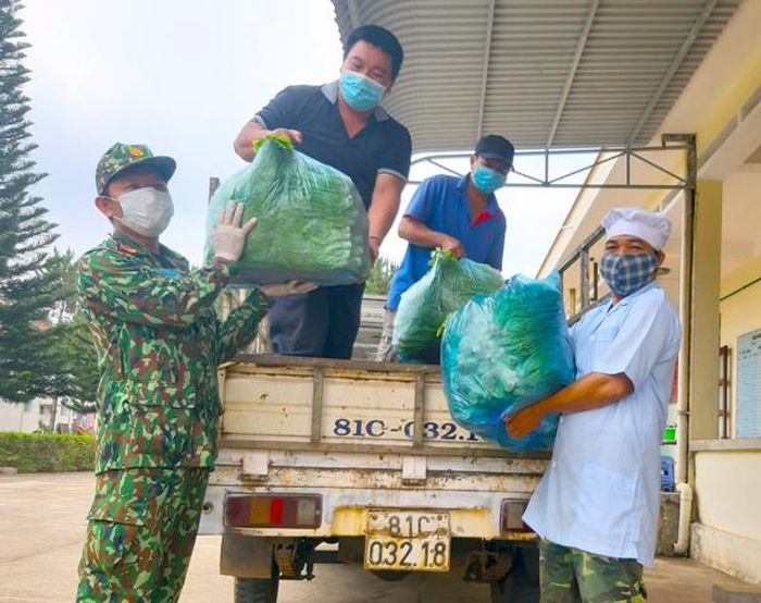Anh Nguyễn Văn Quý (thứ 2 từ trái qua)-Chủ tịch Hội Nông dân phường Hội Thương kêu gọi, vận chuyển rau sạch đến Trung tâm Bồi dưỡng kiến thức quốc phòng-an ninh. Ảnh: P.L