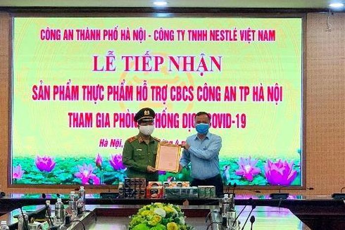 Thiếu tướng Đoàn Ngọc Hùng, Phó Giám đốc Công an thành phố Hà Nội trao thư cảm ơn của Giám đốc Công an thành phố tới đại diện Công ty TNHH Nestlé Việt Nam